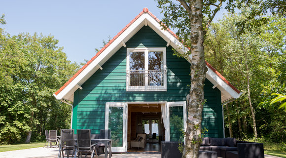 Over Bungalow Kijkduin Achterkant van vakantiehuis Kijkduin op Midsland Noord op Terschelling met stuk gras en de loungeset op het terras